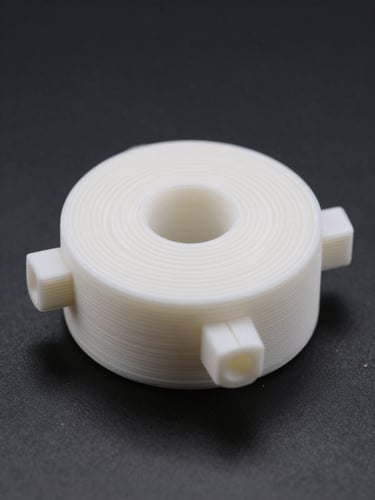 Extreme close-up flatlay of a precision 3D-printed white PLA mechanical part on a matte black surface, studio-bright even light exposing every layer line and surface ridge, depth of field 2cm, shot directly overhead, no shadows