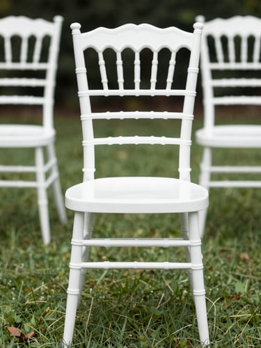 Close environmental shot looking down a row of round banquet tables inside an installed frame tent, white linen draped on each table, folding chairs set in place, natural daylight filtering through translucent sidewalls, hardware connection points visible overhead