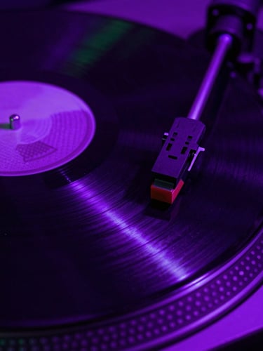 Close-up of spinning vinyl under high-contrast violet neon lights, macro shot of the turntable needle, deep shadows, gritty club photography style