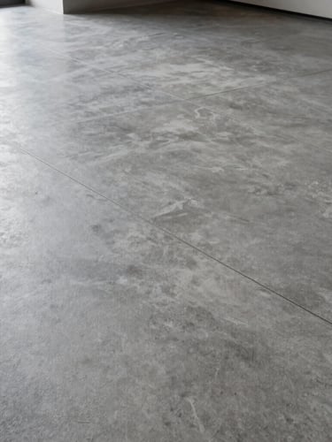 Planos cerrados de líneas de fuga perfectas en un suelo de microcemento gris pulido, luz natural fría entrando lateralmente, composición geométrica.