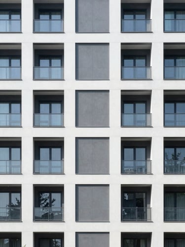 Straight-on architectural photograph of a modern residential building facade, clean geometric lines, bright natural daylight, cool desaturated tones, sharp focus.