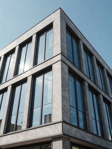 Wide-angle architectural exterior of a modern commercial building with dark tinted windows reflecting a bright blue sky, clean lines, 35mm lens
