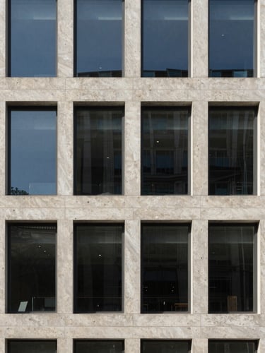 Architectural crop of a minimalist concrete and glass corporate headquarters, soft natural daylight, travertine stone textures, 35mm
