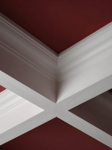 Close-up architectural detail of a coffered ceiling joint, showing flawless trim carpentry integration, crisp white paint, dramatic raking light, sharp focus, premium architectural photography.