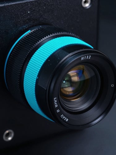Macro technical photography of a high-precision cleanroom instrument with sharp neon cyan highlights on dark charcoal surfaces, 35mm lens
