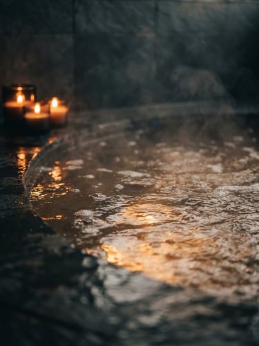 Close-up of steaming private Jacuzzi water with warm candlelight reflecting off the surface, deep slate gray background, soft focus, moody atmosphere.