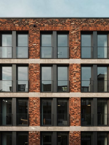Straight-on architectural photograph of a modern London residential brick building facade, soft morning daylight, clean lines, balanced framing.