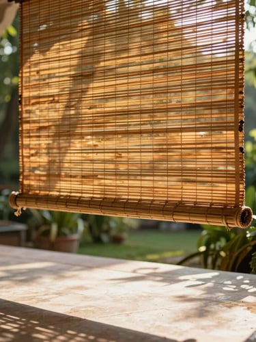 A close-up portrait of hand-woven seasoned bamboo blinds hung in a spacious Lucknow verandah. Warm afternoon sunlight filters through the fine bamboo splits, casting intricate, soft golden shadows onto a polished stone floor. Lush green garden foliage is softly blurred in the background.