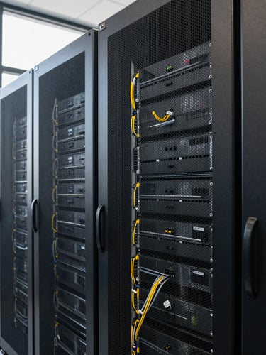 Medium shot of a modern, clean server room in Conakry with structured cabling, bright natural daylight from a high window, technical precision, no people.