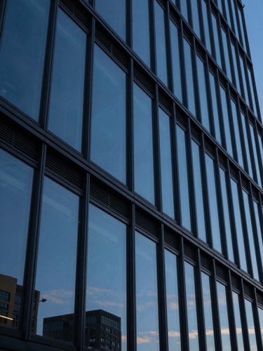 Macro shot of sharp modern architectural lines of a corporate headquarters reflecting a deep blue twilight sky, high-contrast cinematic lighting.
