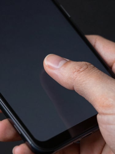 Extreme close-up, thumb mid-tap on a dark Android phone screen, single UI element illuminated under clean studio light, sharp focus on the fingertip and the screen surface, high contrast, minimal background