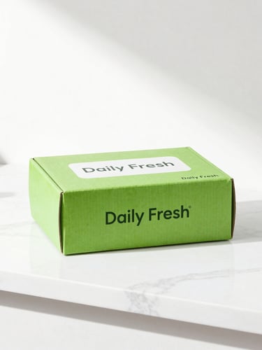 Bright high-key studio shot of a clean minimalist Daily Fresh delivery box on a white marble counter, morning sunlight casting soft shadows.