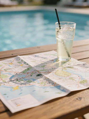 A map spread out on a warm wooden table next to a cold drink by a pool, soft natural sunlight, shallow depth of field