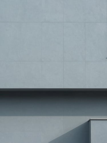 Minimalist architectural photography of a modern tech hub facade, clean geometric shadows, cool morning daylight, desaturated slate blue tones, 35mm