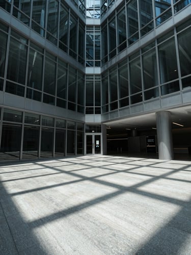 A stark, high-contrast architectural photograph of a modern corporate atrium with glass panels and sharp geometric shadows, cool clinical lighting, wide angle.