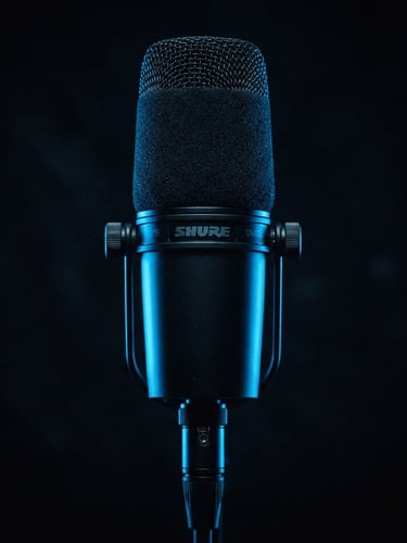 High-contrast macro shot of a professional studio microphone, deep obsidian background, sharp electric blue rim lighting, cinematic 35mm