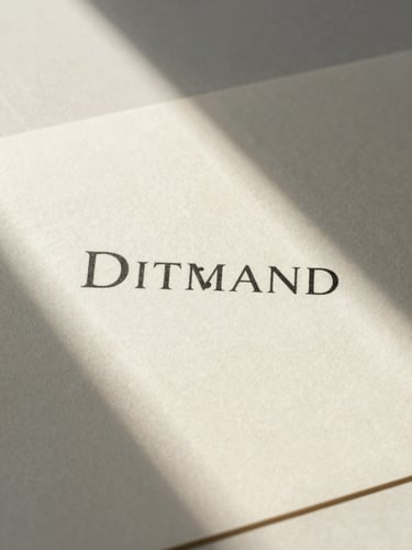 Macro portrait of printed brand collateral on textured warm cream paper stock, soft directional north-facing window light, natural shadows, minimalist visual design layout