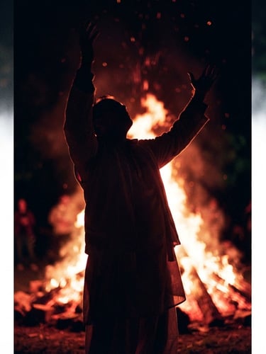 Low-angle dramatic editorial photography of a passionate worshiper with raised hands silhouetted against a deep crimson and gold firelight glow, high-contrast shadows, 35mm