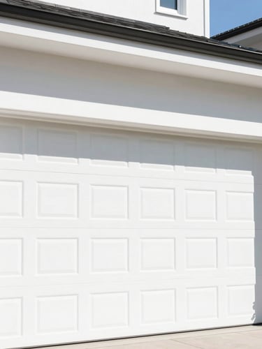 Bright saturated afternoon sunlight on a pristine white garage door installed on a modern home, showing clean architectural lines and sharp focus.