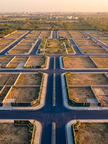 Warm golden-hour aerial view of neatly demarcated residential plots in Kanpur, clean wide roads, professional real estate photography