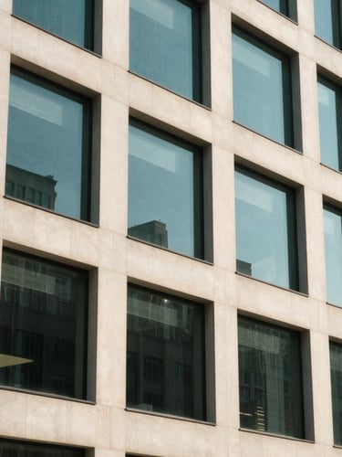 An architectural close-up of a modern corporate office building facade, clean geometric lines, bright natural daylight, soft shadows, 35mm photography