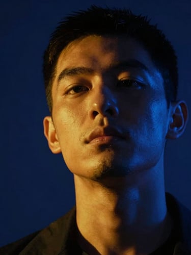Dramatic low-angle shot of a high-intensity character close-up under neon-noir lighting, strong amber highlights, deep midnight blue shadows, strict vertical 9:16 crop.