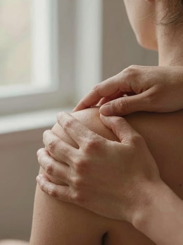 Close-up of hands guiding a therapeutic movement on a patient's shoulder, soft natural window light, warm terracotta tones, 35mm photography