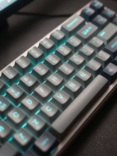 Extreme close-up overhead shot of a mechanical keyboard with terminal code reflected on keycaps, soft cyan glow from a monitor just off-frame, sharp focus on the central keys, dark matte desk surface surrounding