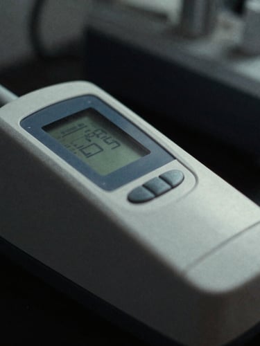 Macro close-up of a high-end medical lactate analyzer in a dark clinical lab, sharp side-lighting, cool desaturated tones, 35mm film grain