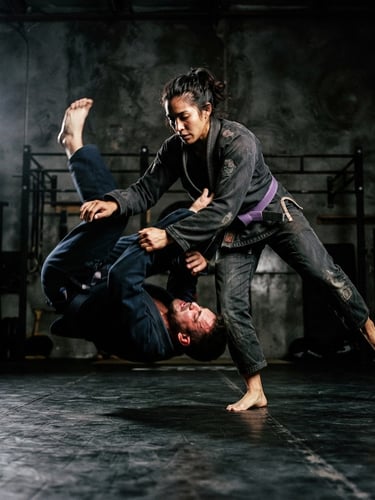 Low-angle dynamic action shot of a BJJ athlete in a dark charcoal gi, dramatic high-contrast studio key light, deep shadows, dark technical concrete background, 50mm lens