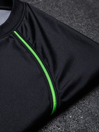 Tight macro shot of reinforced stitching on a black MMA rashguard fabric, extreme close-up, neon-green thread details, high-contrast studio lighting