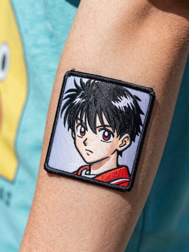Extreme close-up of a crisp manga patch tattoo on a forearm, bright natural daylight, colorful streetwear background, 35mm