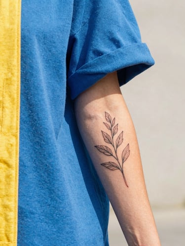 Vibrant lifestyle photo of a young person in colorful streetwear smiling, showing a fresh fineline botanical tattoo on their forearm, bright natural daylight, 35mm