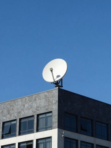 Wide-angle editorial shot of a Starlink antenna installed on a modern office roof in Maputo, bright natural daylight, clear sky, deep blue tones