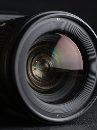 Macro shot of a high-end camera lens reflecting studio lights, sharp focus, cinematic 35mm, moody monochrome.