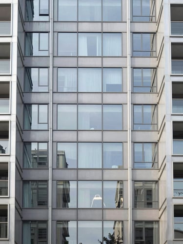 Symmetric architectural photography of a modern glass and steel facade in São Paulo, bright natural daylight reflecting off clean surfaces, 35mm