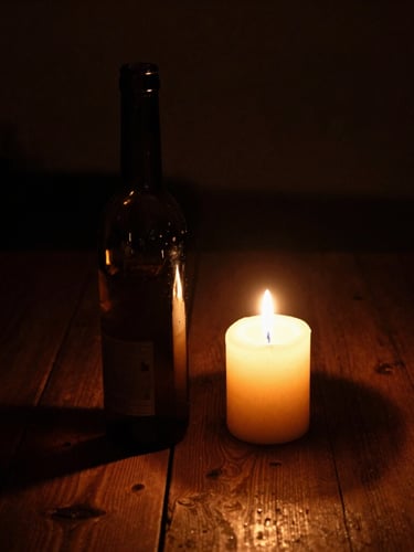 A tight vertical portrait of a wax-dipped dark glass bottle next to a single glowing candle on a rough wooden table, deep shadows, amber highlights, moody 35mm film grain.