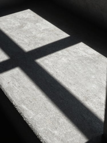 extreme close-up of sharp geometric architectural shadows on concrete, high-contrast natural light, cool tones