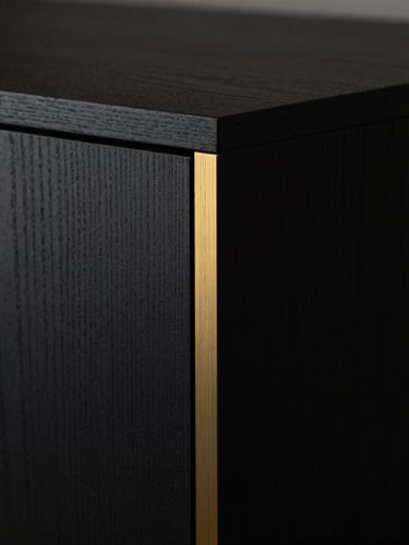 Moody close-up of a dark textured oak cabinet corner with seamless invisible joinery, soft side-lighting catching a subtle brushed gold metallic inlay, Hasselblad medium format