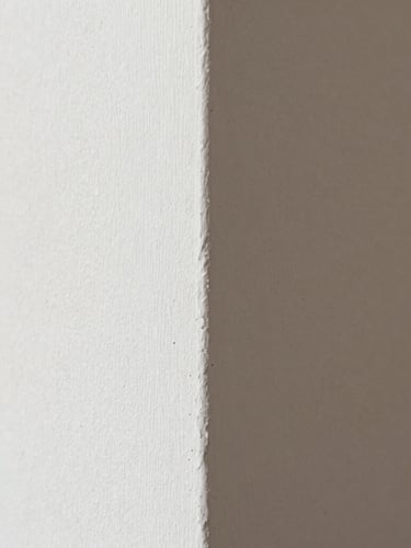 Macro close-up of a perfectly sanded plaster wall corner, crisp daylight revealing a flawless matte texture, clean work environment, 35mm lens