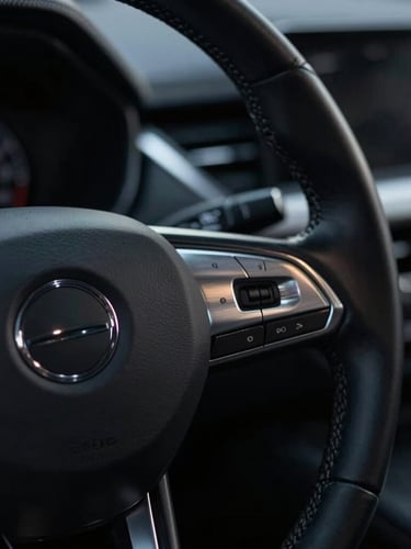 Tight cinematic close-up of a premium leather steering wheel and brushed silver dashboard details, moody low-key lighting, shallow depth of field.