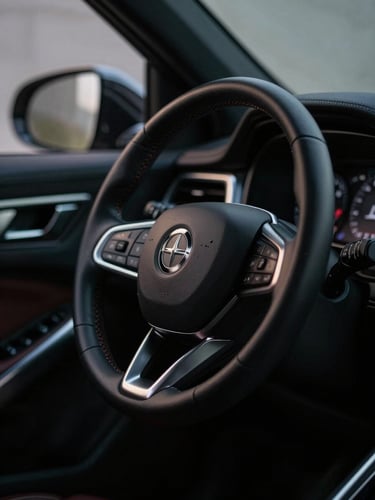 Moody close-up of a luxury vehicle steering wheel and dashboard, low-key dramatic lighting with silver highlights, cinematic framing, shallow depth of field