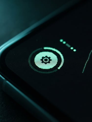 Macro shot of an Android smartphone screen displaying a clean, dark-mode UI with crisp mint green elements, shallow depth of field, low-key studio lighting with cyan accents.