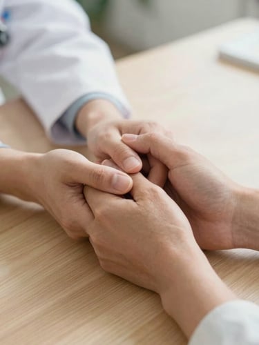 A close-up shot of a clinician's hands gently holding a patient's hand over a light wooden table, soft natural daylight, warm and reassuring atmosphere, focusing on the human connection.