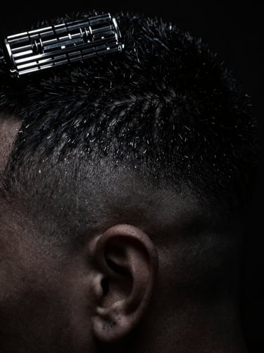 Macro close-up of a razor-sharp skin fade under dramatic low-key studio lighting, sharp silver reflections, deep matte black background, high contrast
