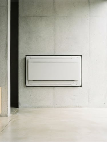 Straight-on architectural photography of a sleek modern indoor heat pump unit integrated into a minimalist concrete wall, bright natural morning daylight, crisp details, 35mm lens