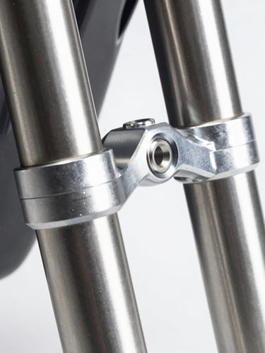 Extreme close-up of machined mechanical joints and suspension forks, cool high-contrast studio lighting, metallic silver and deep charcoal tones, sharp focus, 50mm lens