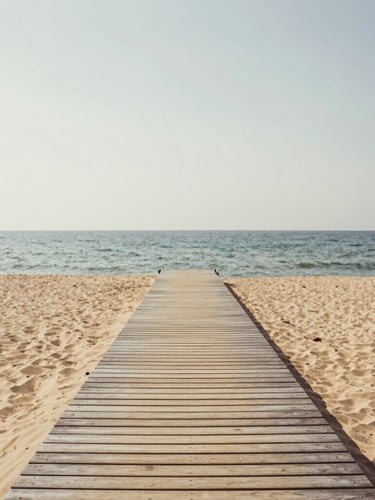 Calm coastal landscape with a subtle wooden dock stretching towards a clear horizon, soft overcast daylight, warm sand tones, editorial photography