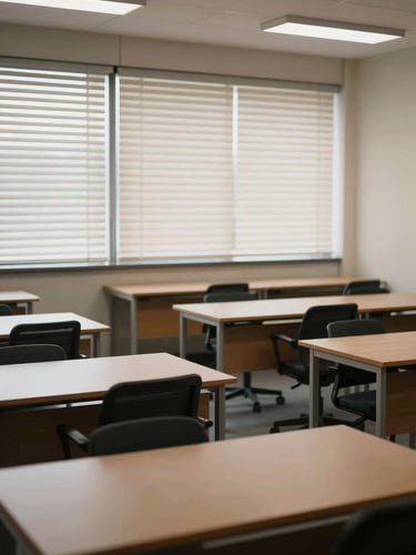 Wide-angle view of an empty small office interior just cleaned, rows of desks cleared, soft daylight through venetian blinds casting gentle stripes, calm and orderly