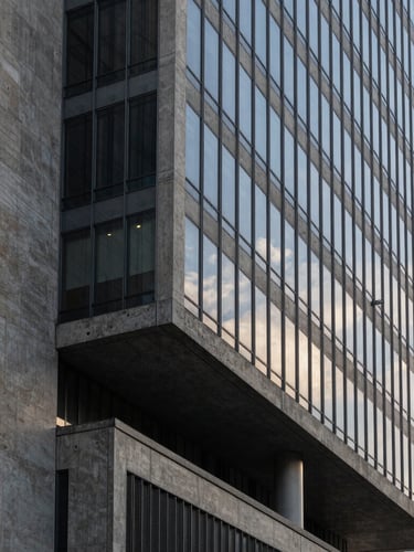 Geometric architectural crop of a modern concrete and glass corporate headquarters in São Paulo, sharp shadows, cool diffused morning light, minimalist composition.